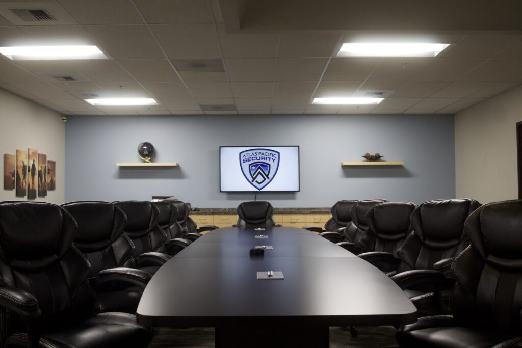 A large meeting room with Atlas Pacific Security branding on the wall.